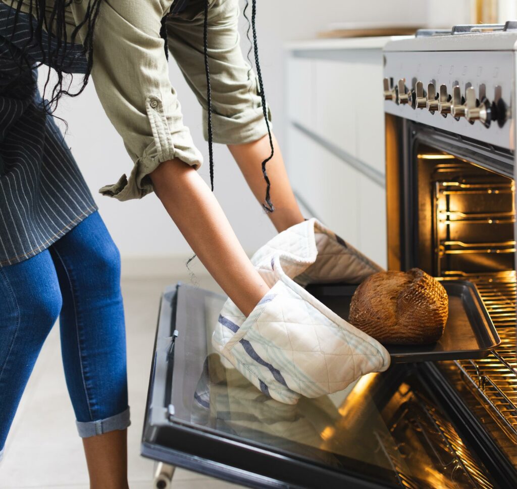 mujer cocina con el horno electrico